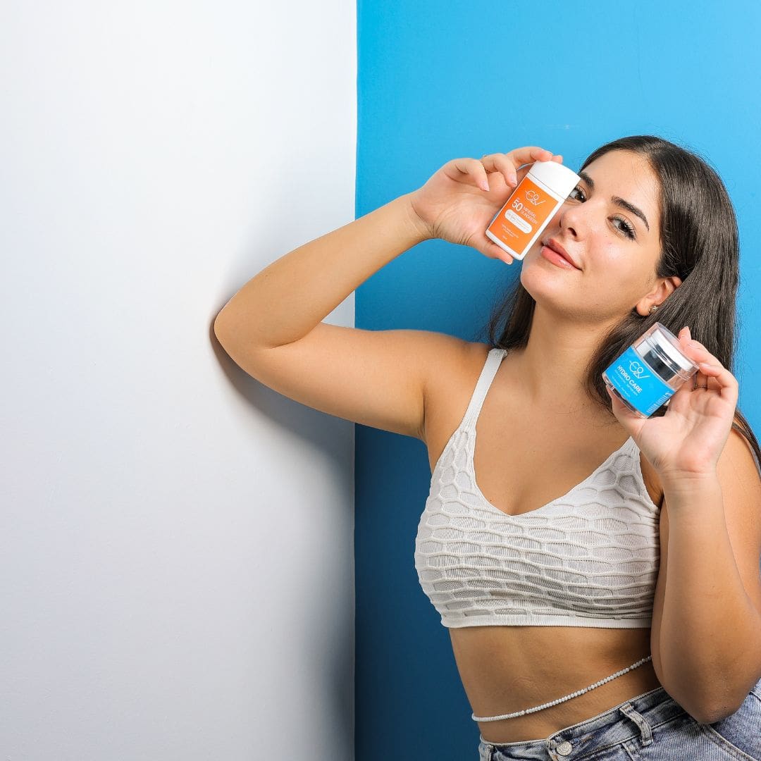 Woman holding moisturizer and sunscreen showing skincare routine